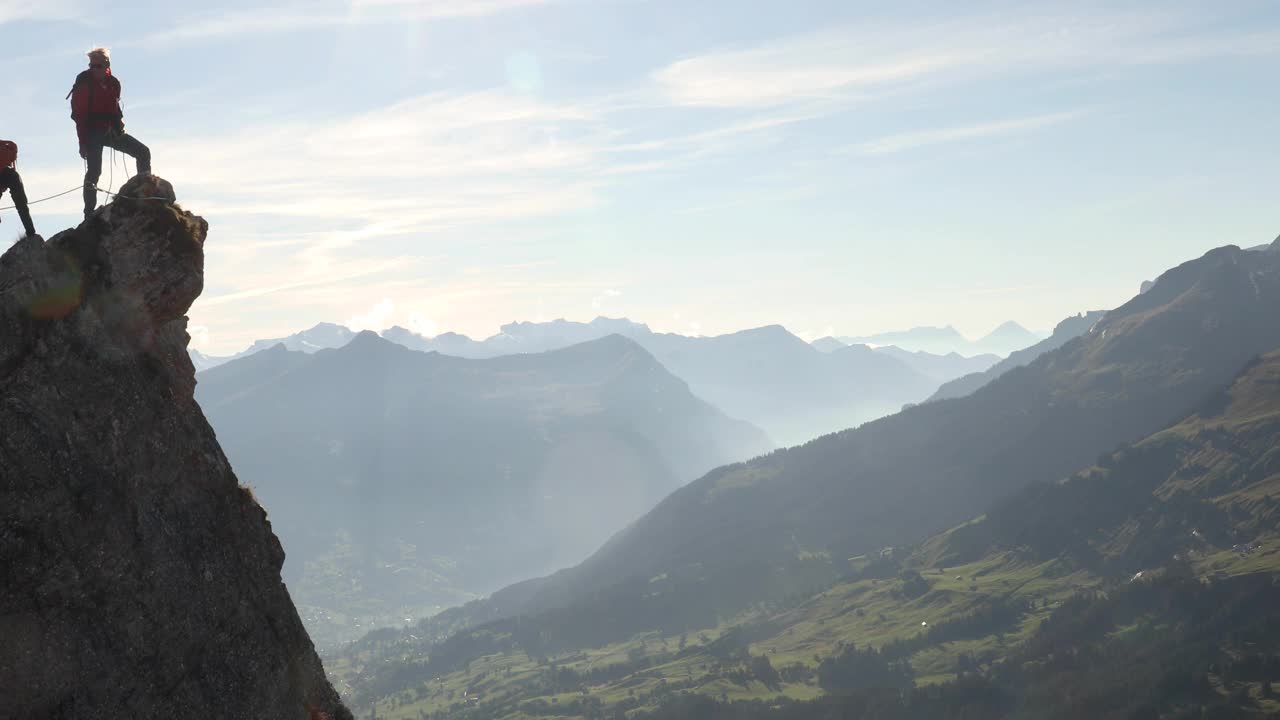 男性登山运动员登上岩石的顶峰视频下载