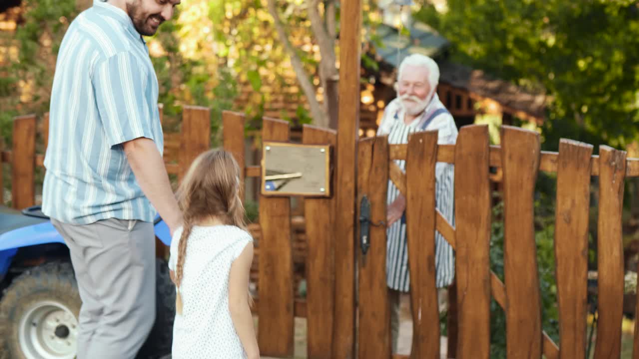 当他们站在家门口时，孙女兴奋地跑去拥抱他们的祖父视频素材
