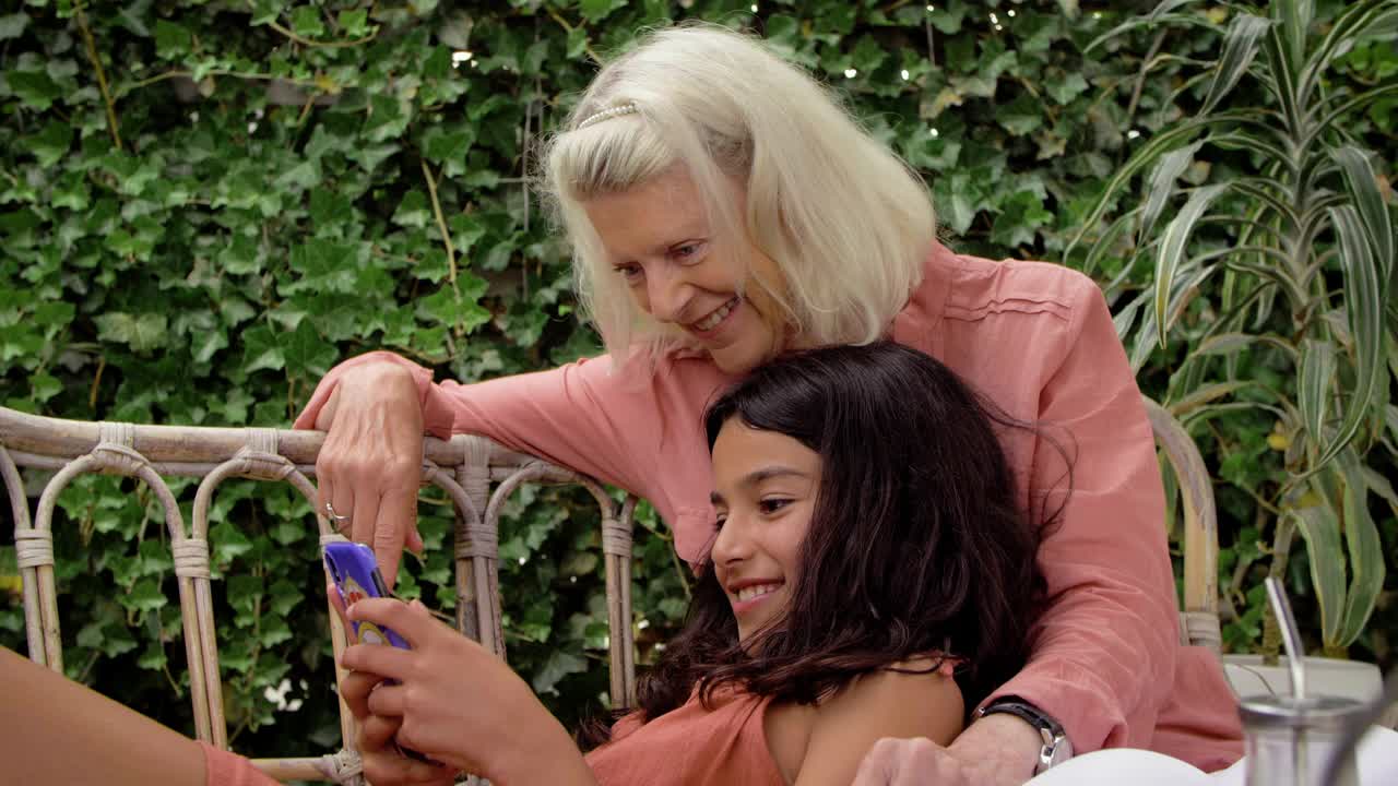 微笑的孙女在后院和奶奶玩智能手机视频下载