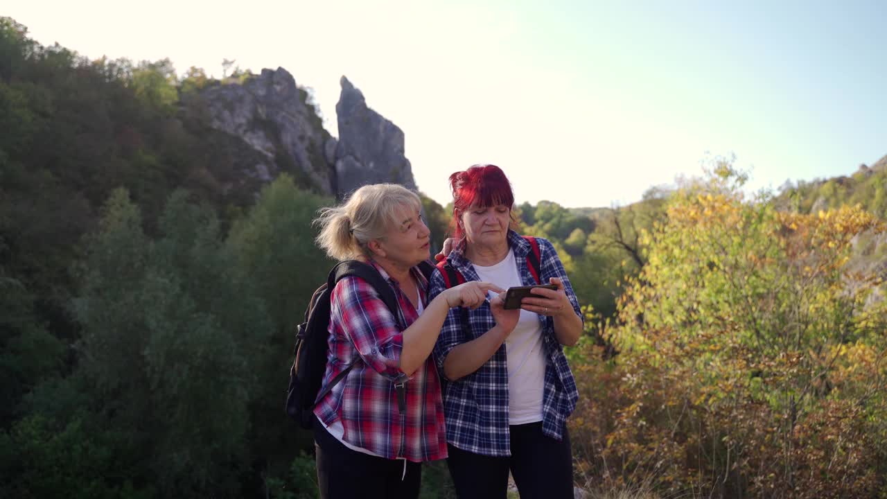 两位活跃的高级女性使用手机应用导航视频下载