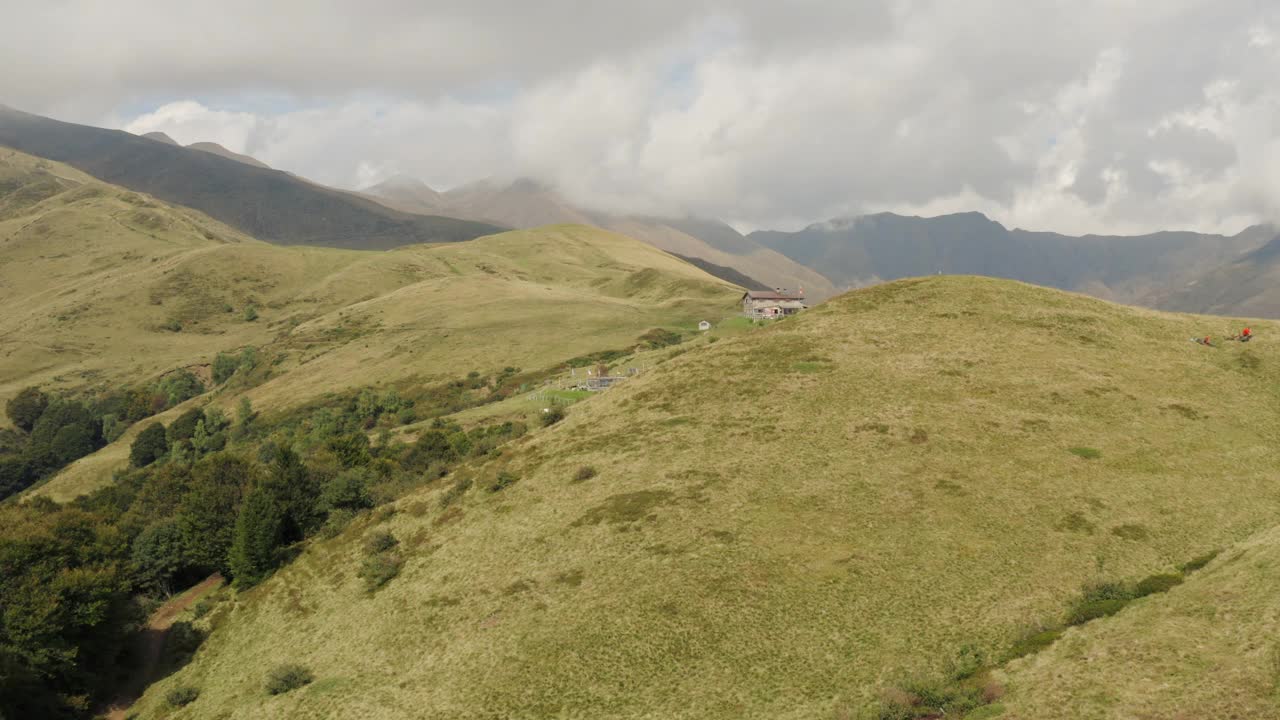 无人机拍摄的山地农场在草地山坡上的山区视频素材