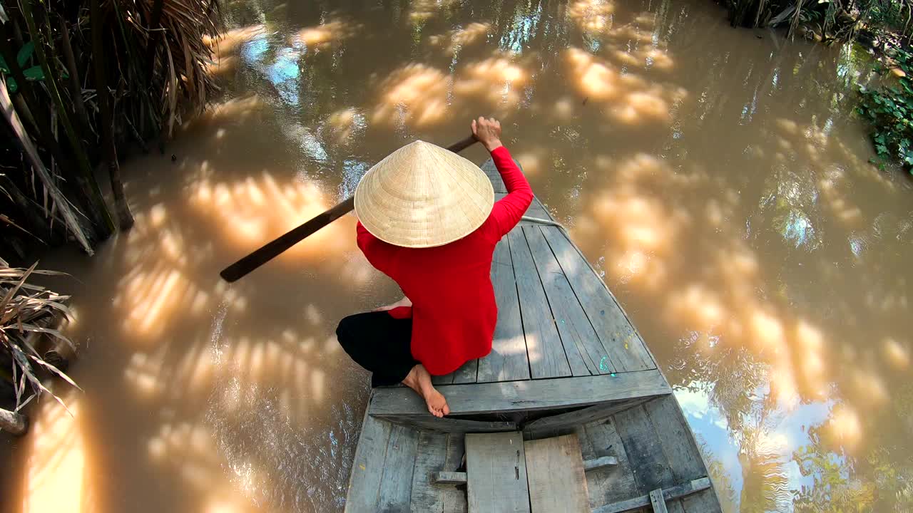 亚洲女性戴着圆锥帽划船舢板越南视频素材