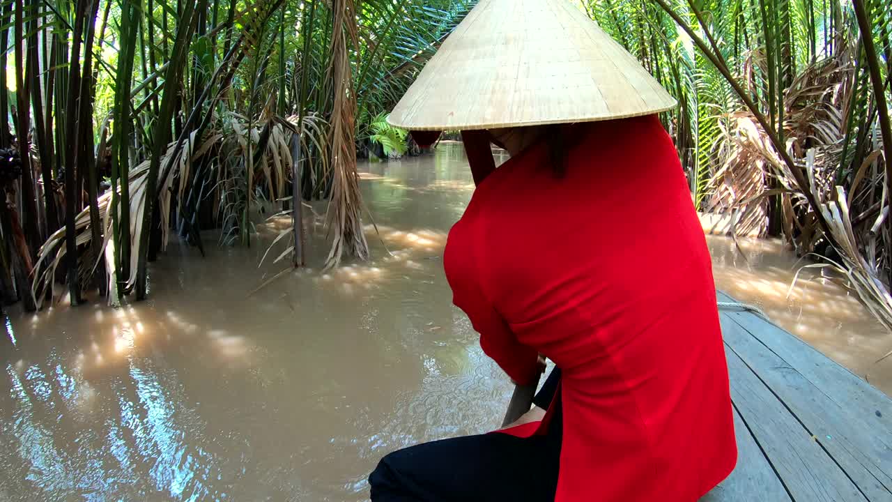 女子划船舢板通过湄公河热带雨林越南视频素材