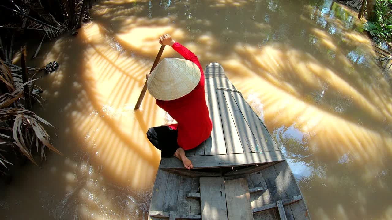 亚洲女性戴着圆锥形帽子划桨舢板越南视频下载