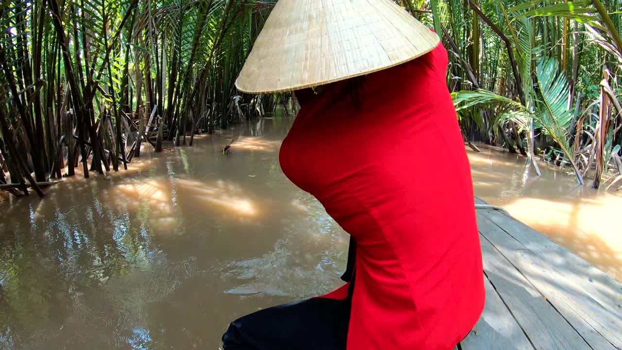 亚洲女子划着舢板沿着丛林运河越南视频素材