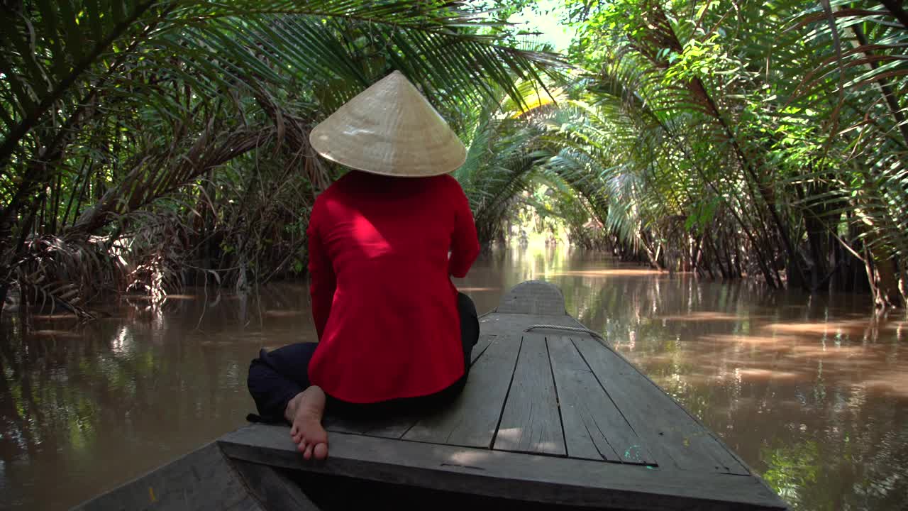 亚洲女士划着舢板穿过椰子树越南视频素材