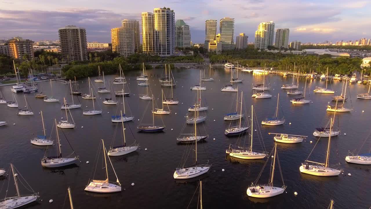 美国佛罗里达州迈阿密，日落时分，椰林码头的帆船和市中心的建筑视频下载