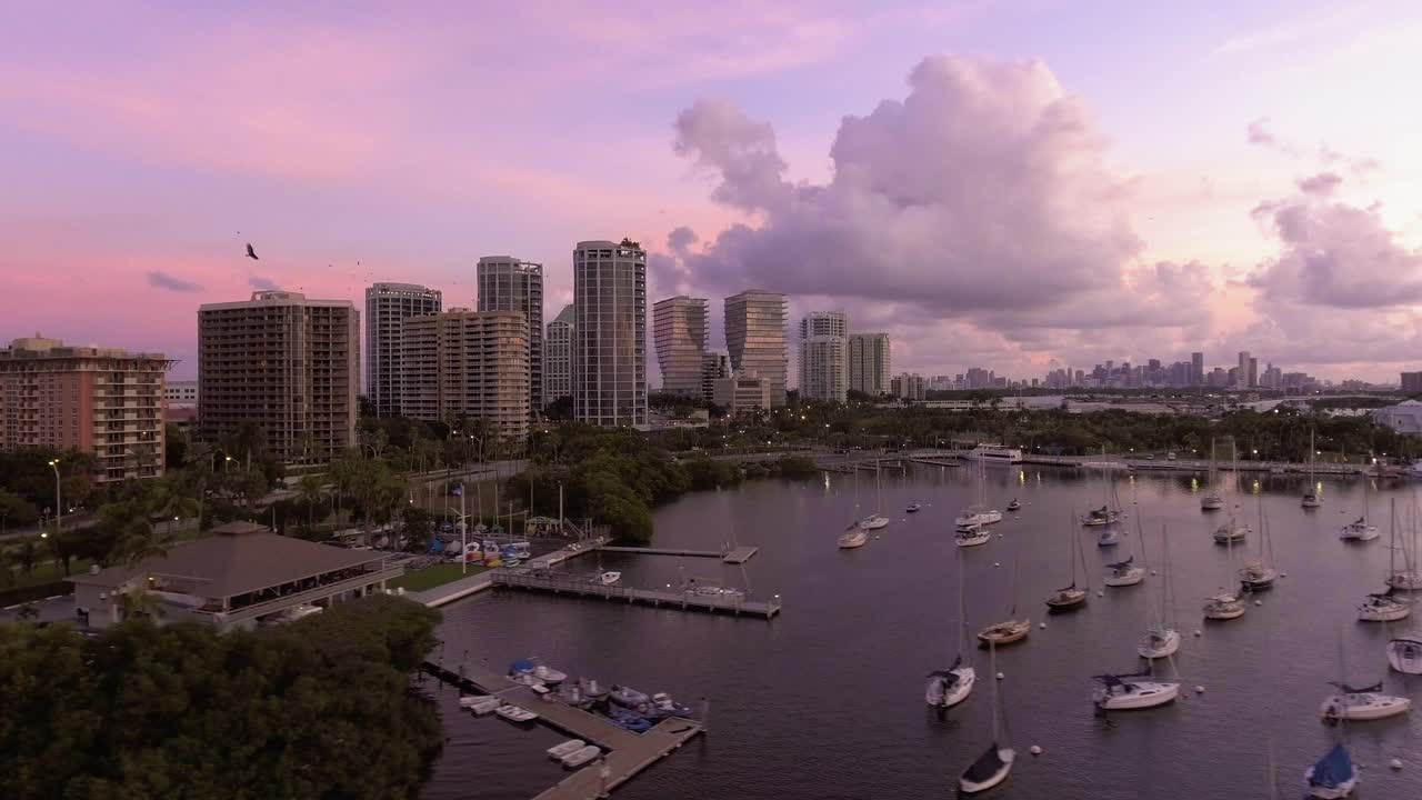 美国佛罗里达州迈阿密，日出时分，椰林码头的帆船和市中心的建筑视频下载