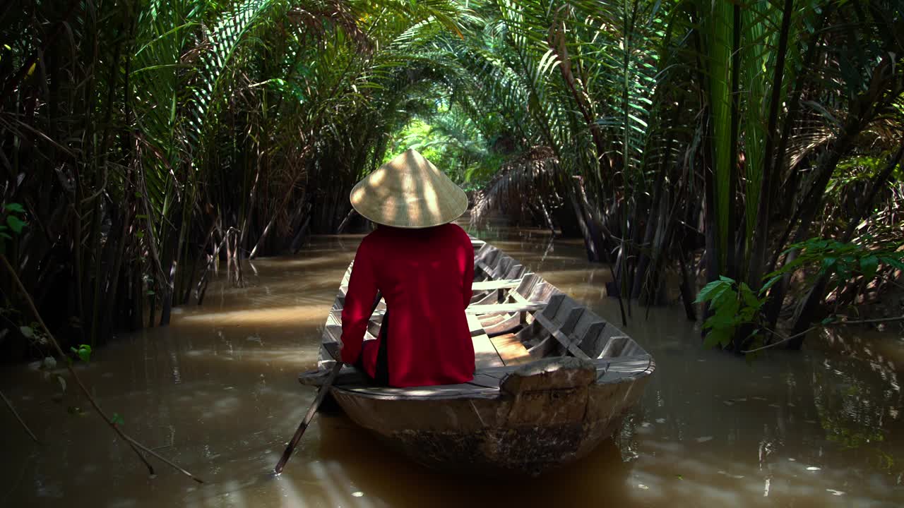 亚洲女子划桨舢板下的热带棕榈越南视频下载