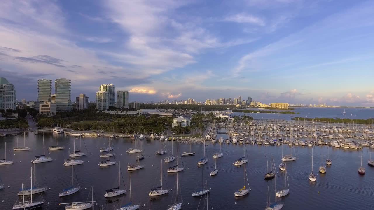 美国佛罗里达州迈阿密，日落时分，椰林码头的帆船和市中心的建筑视频下载