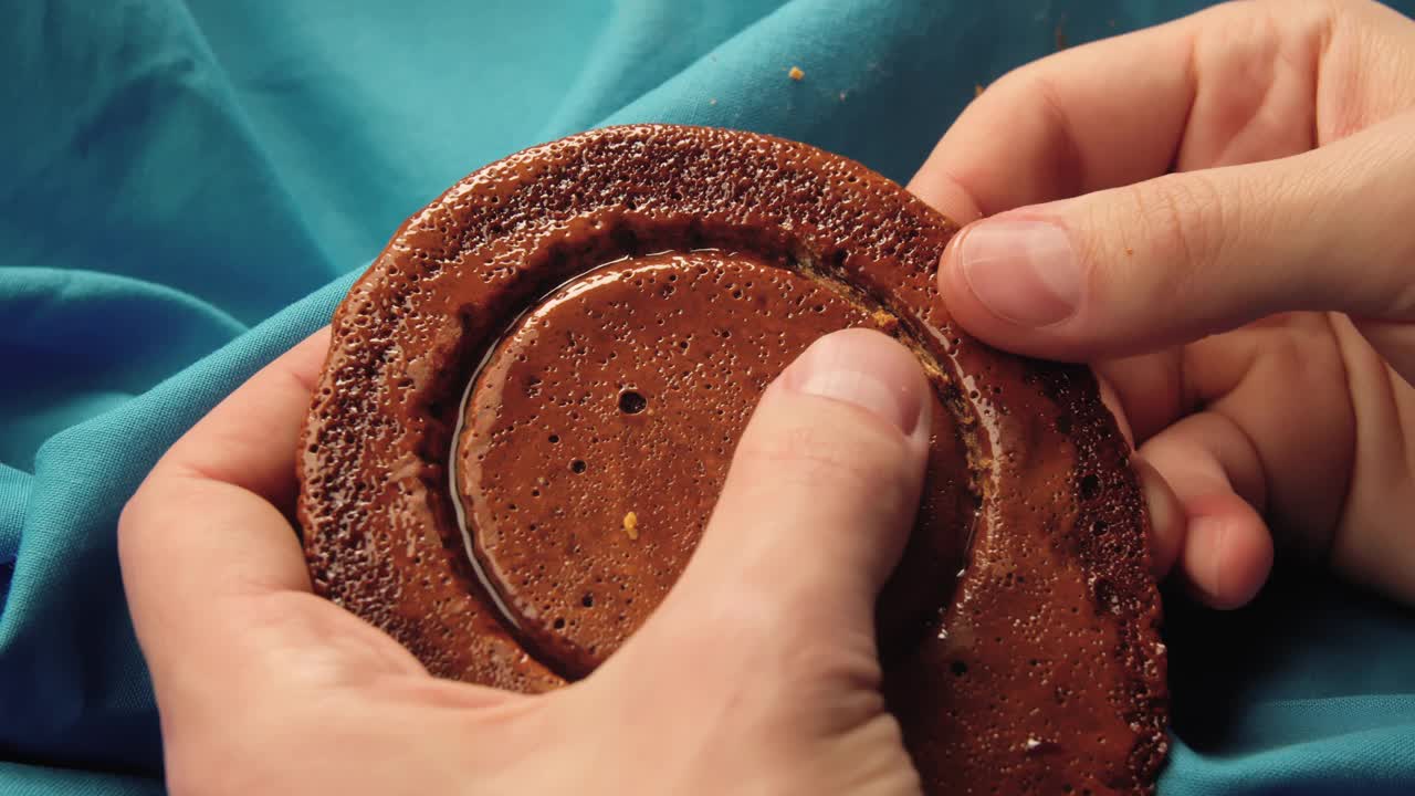 男人的手把糖饼干掰成一个圆圈的形状。视频下载