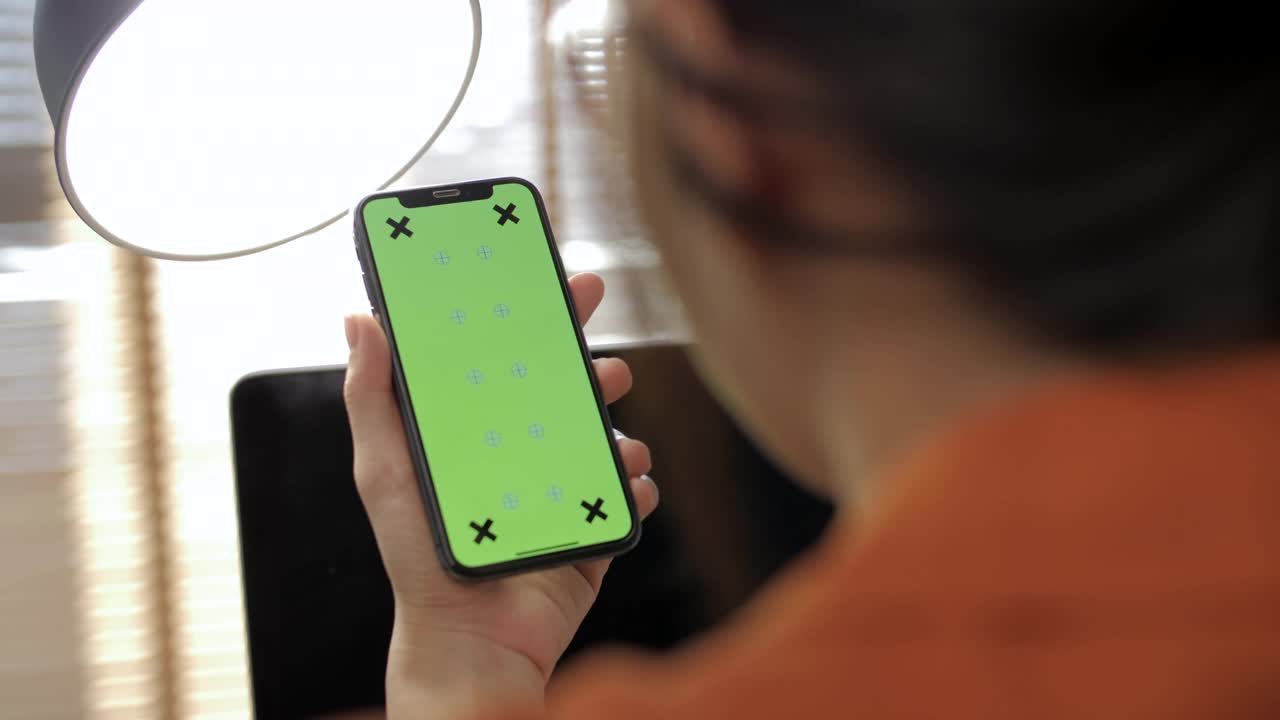 女性使用带有绿色色度键屏幕的智能手机视频下载