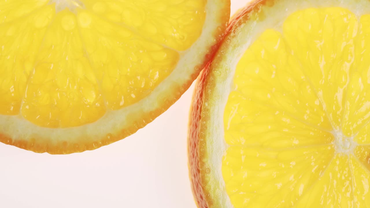一个美味多汁的橙子切片旋转白色发光的背景，微距拍摄。视频素材