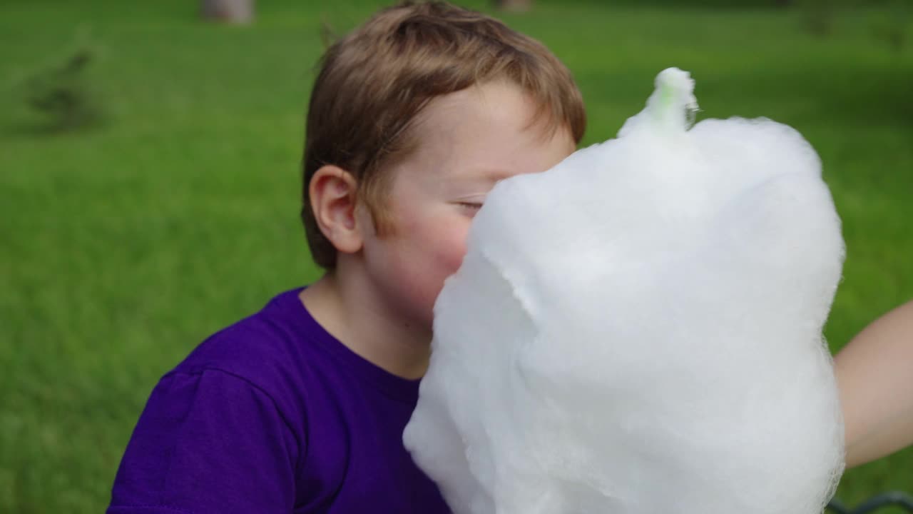 红发男孩在公园里吃棉花糖视频下载