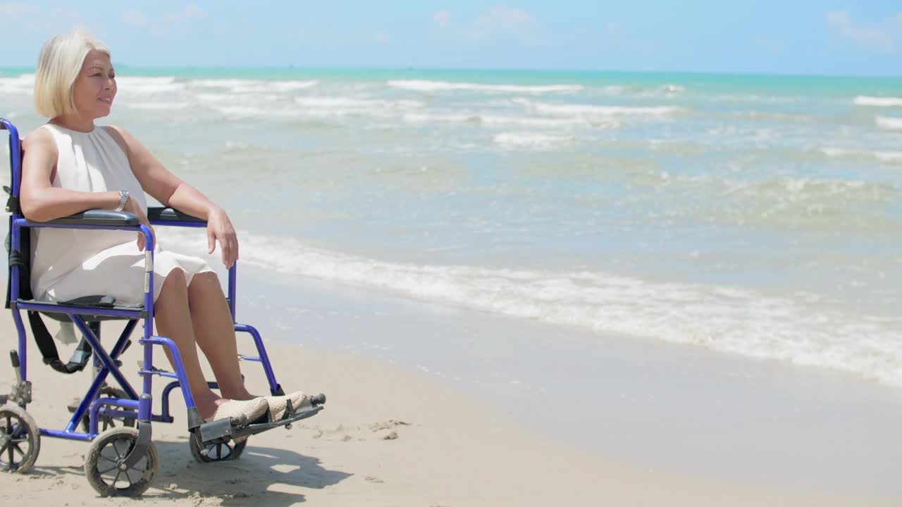 孤独的残疾人坐在轮椅上看着海滩视频下载