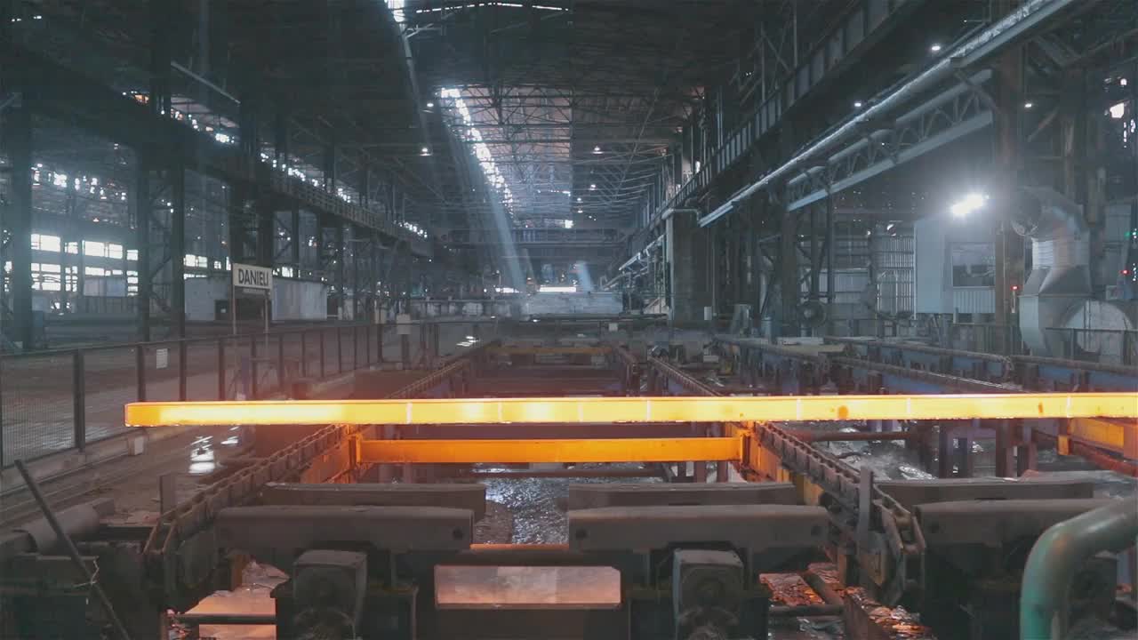 在冶金厂生产轧制金属。烧红的金属。传送带上的热金属。视频素材