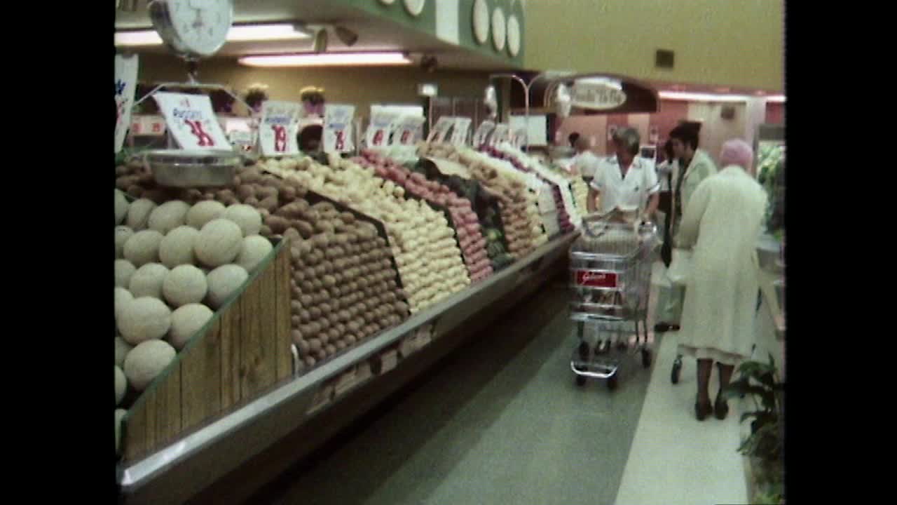 人们在美国超市的水果和蔬菜通道购物;1979视频下载