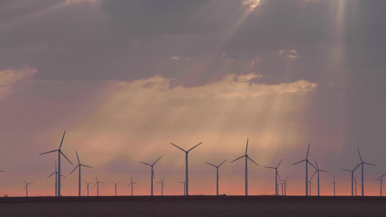 阳光穿过云层照耀着风力涡轮机，罗斯科，德克萨斯州，美国视频下载