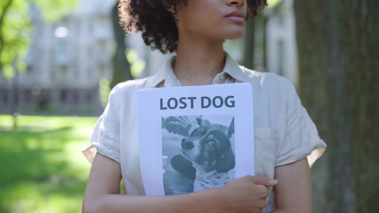 女狗主人手拿海报，寻找走失的宠物视频素材