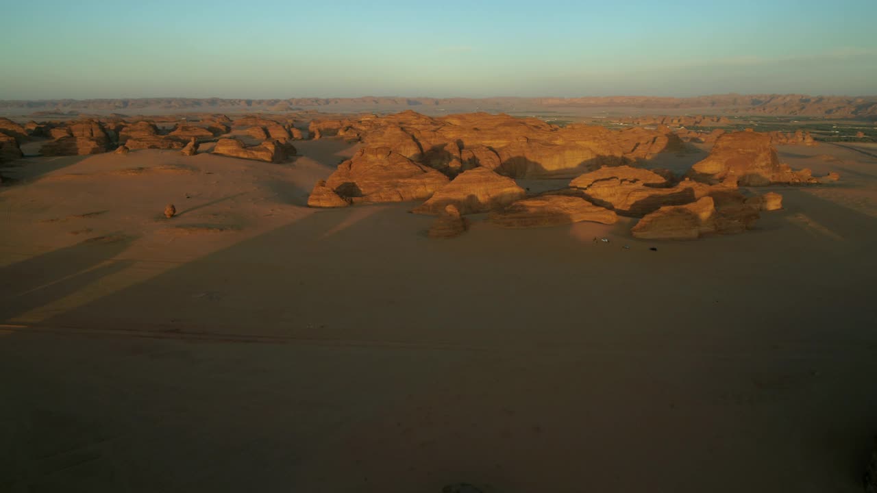 空中拍摄的游客探索著名的象岩，无人机在日落时飞过沙漠-阿卢拉，沙特阿拉伯视频下载