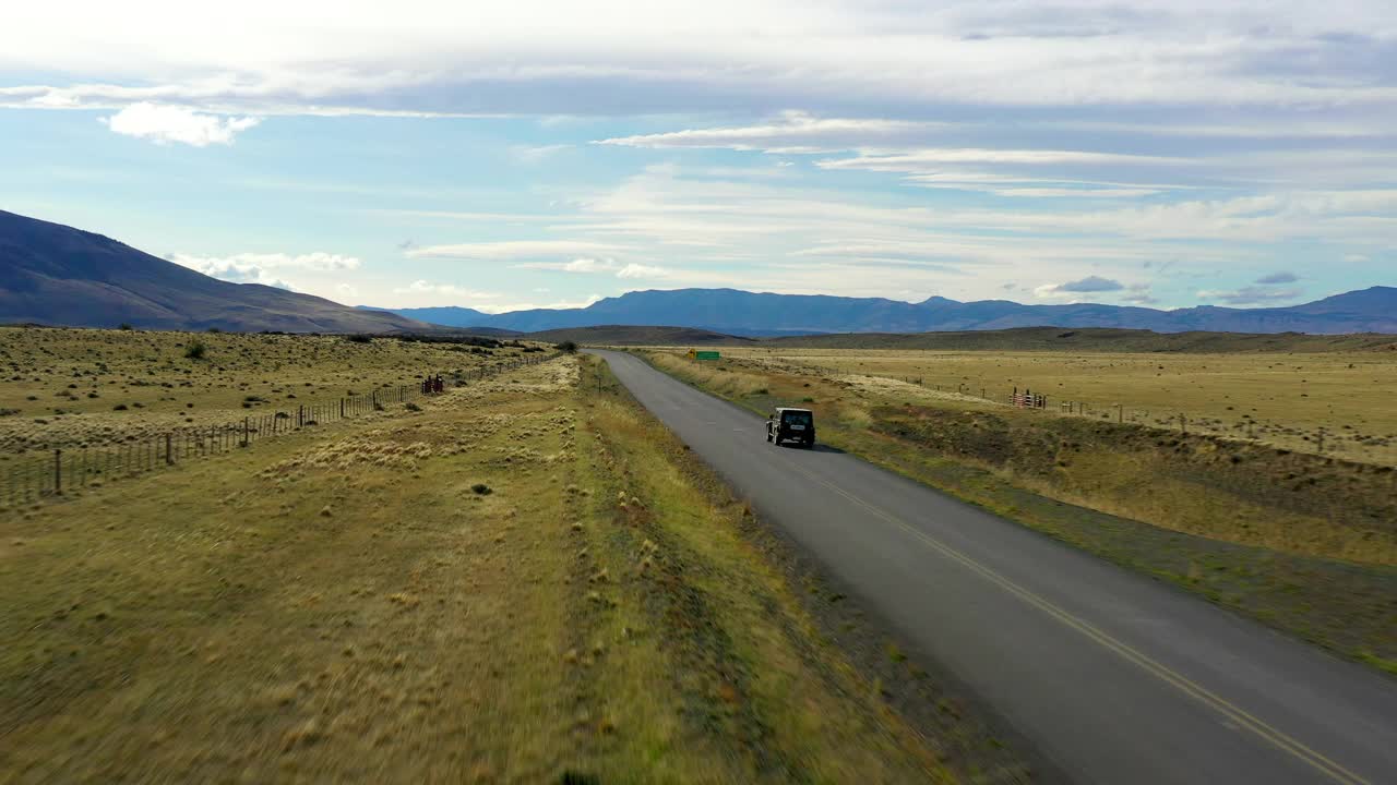 航拍:汽车在道路上移动的美丽镜头，无人机在绿色景观上空飞行-纳塔莱斯港，智利视频素材