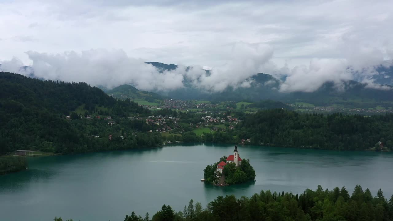 空中风景拍摄的教堂在绿色的风景中，无人机飞过湖泊流血视频下载