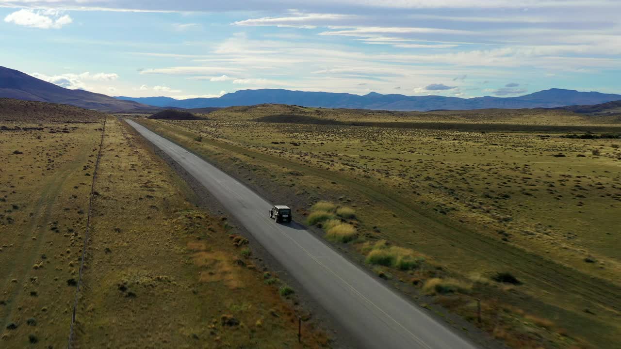 鸟瞰图:汽车在阳光下行驶在道路上，无人机在绿色景观上飞行-纳塔莱斯港，智利视频素材