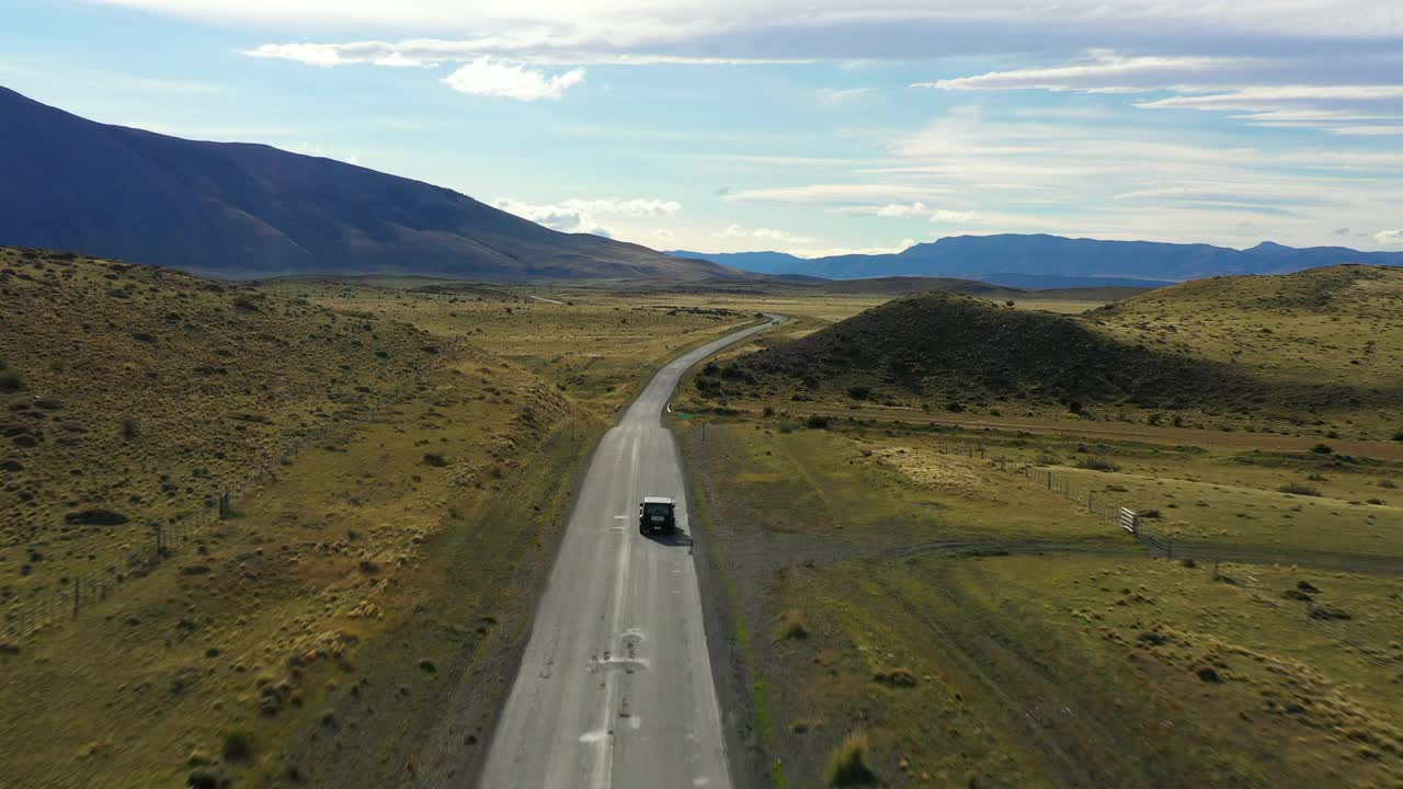 空中拍摄:美丽的山景和绿色景观，阳光下的车辆移动道路-纳塔莱斯港，智利视频素材
