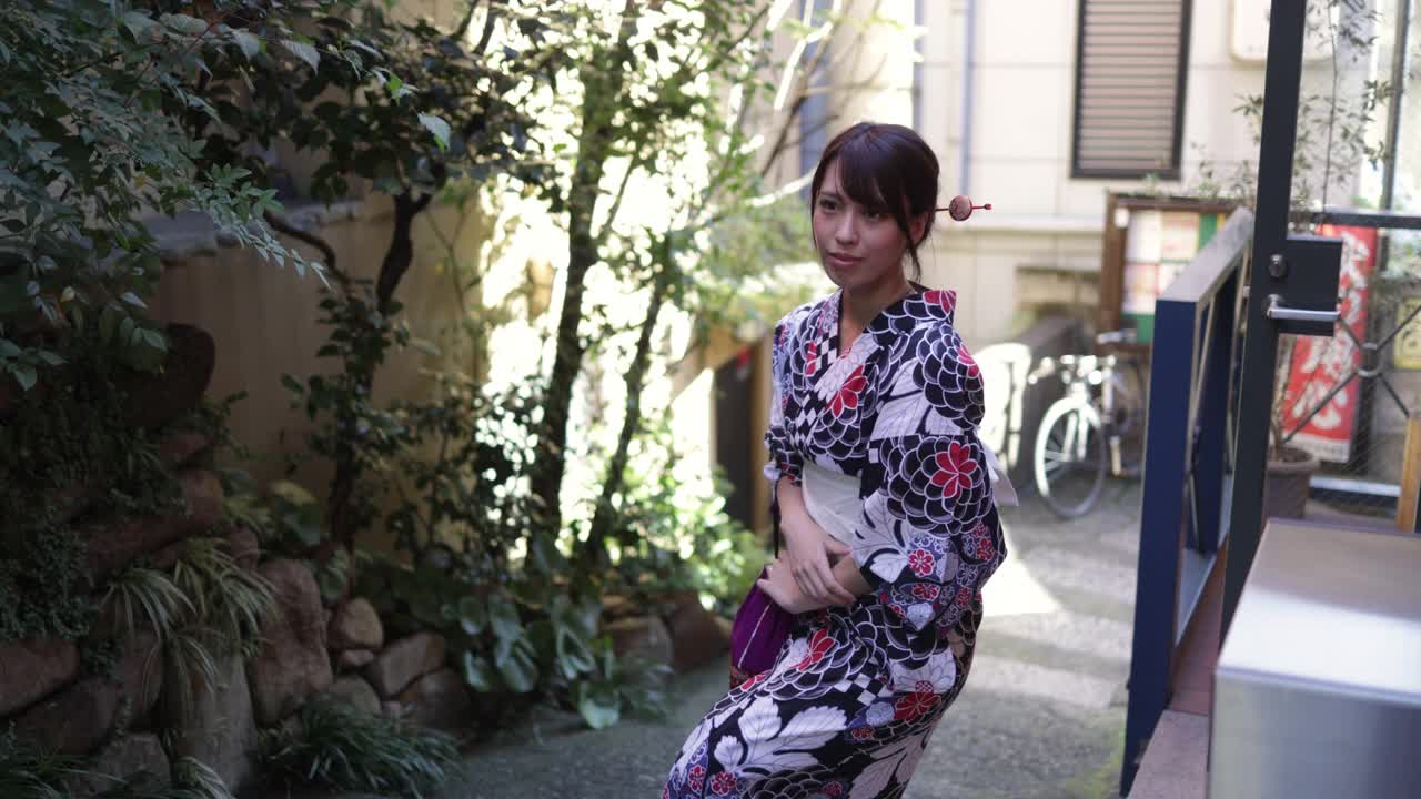一名日本女子在一条狭窄的小路上走着视频素材