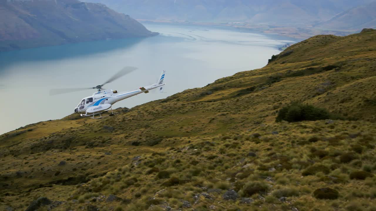 航拍:拍摄直升机在山中的河流上移动的风景-奥克兰，新西兰视频下载