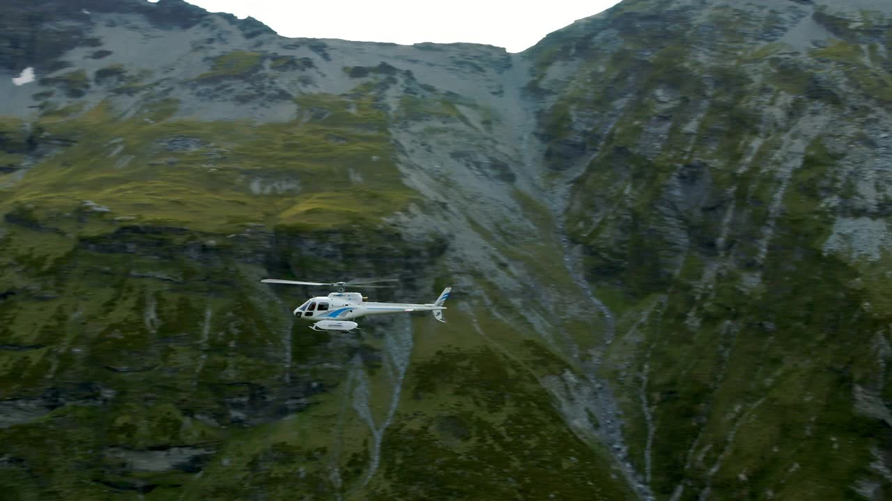 航拍:冬季直升机在绿色山脉上移动的美丽镜头-新西兰奥克兰视频素材