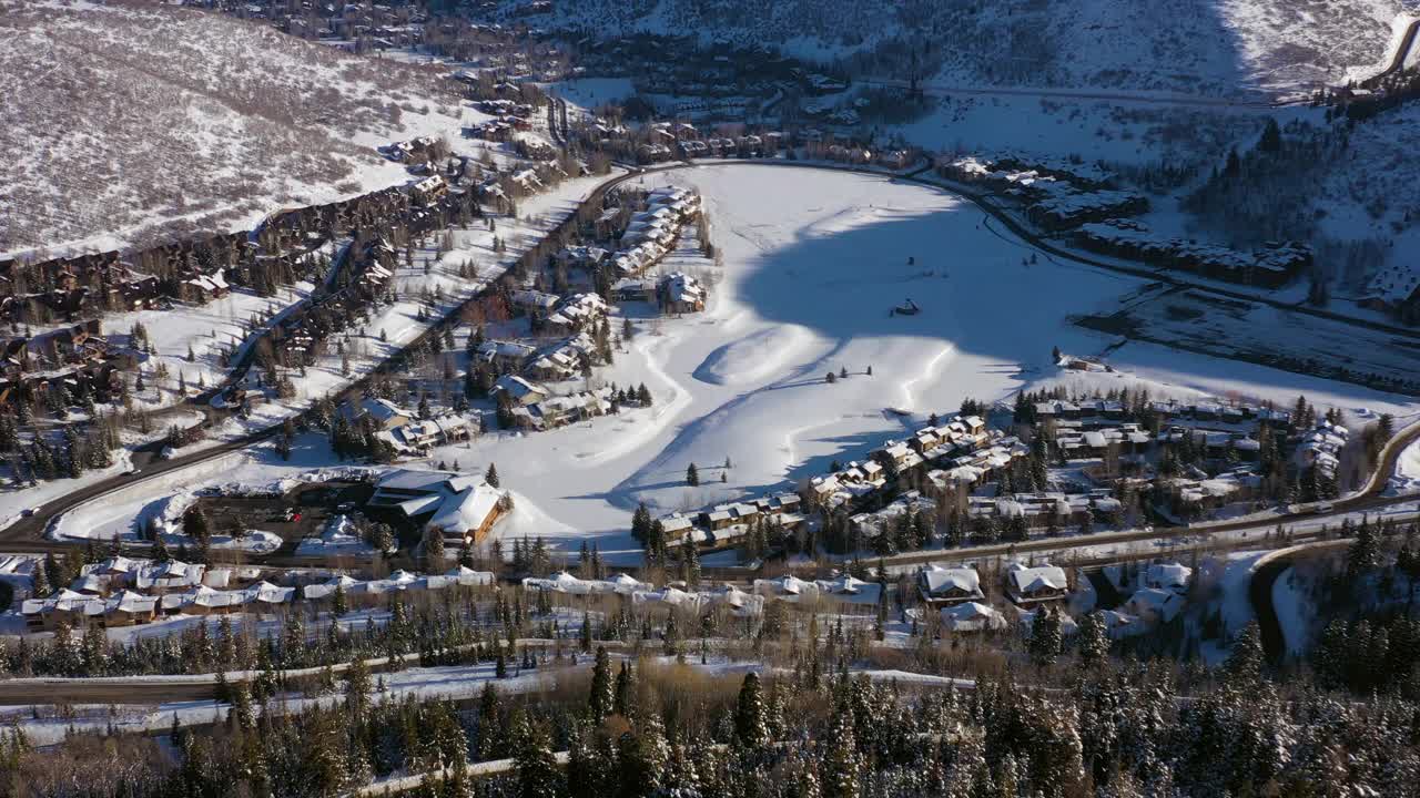 空中拍高的住宅社区在一个雪山滑雪镇安静的街道和明亮的早晨阳光-帕克城，犹他州视频素材