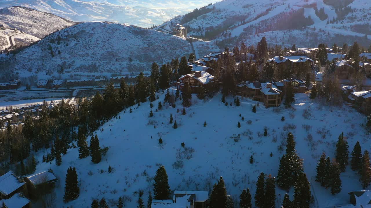 空中拍居民区在一个雪山滑雪镇与安静的街道和明亮的早晨阳光-公园城，犹他州视频素材