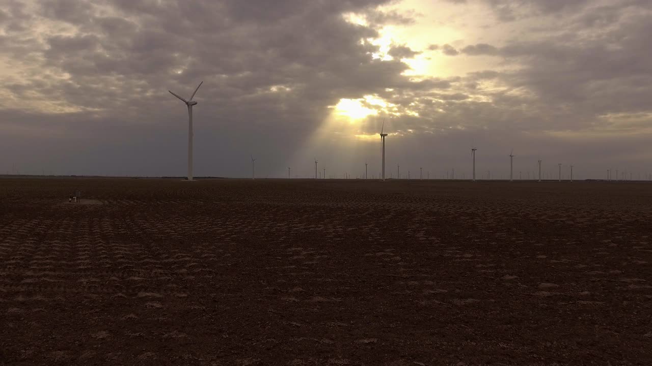 阳光穿过云层照耀着风力涡轮机，斯奈德，美国德克萨斯州视频下载