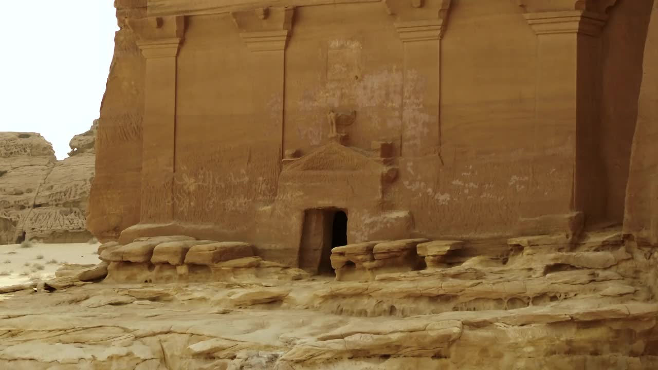 空中拍摄阿拉伯沙漠中古老的Madain Saleh坟墓的入口视频下载