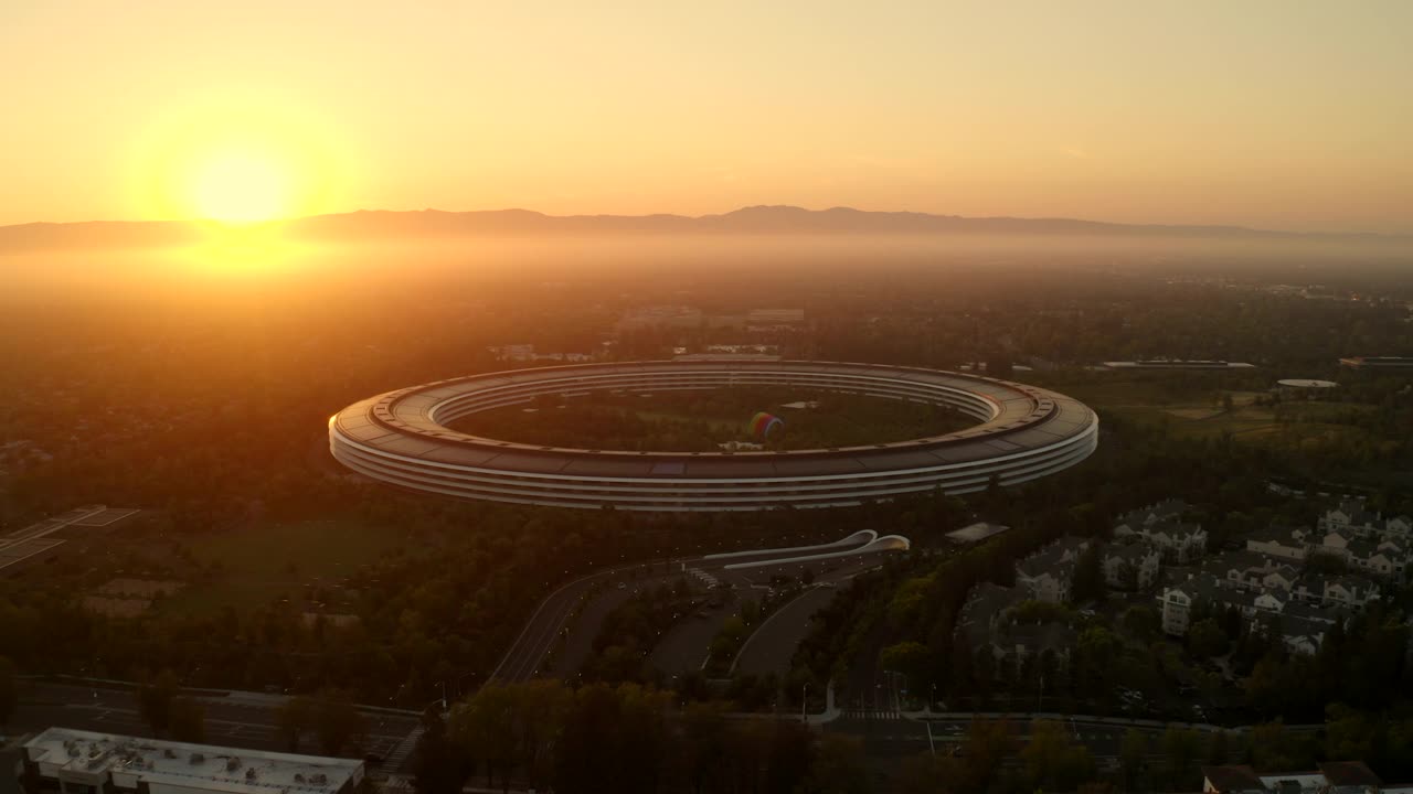 空中拍摄的美丽的苹果校园，无人机在日落时飞过树木-加州库比蒂诺视频下载