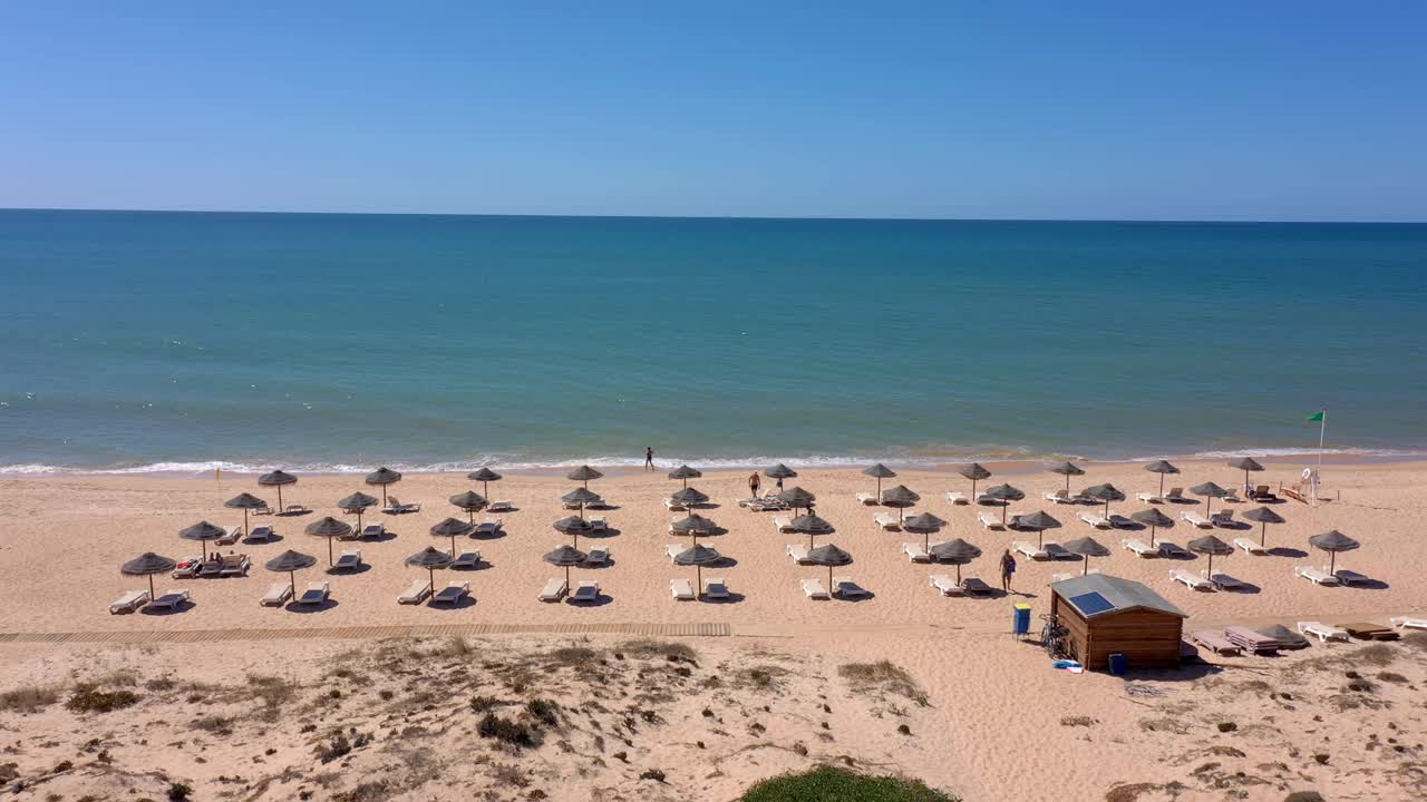 沙丘海岸度假海滩的鸟瞰图。为游客准备的雨伞和日光浴椅。视频素材