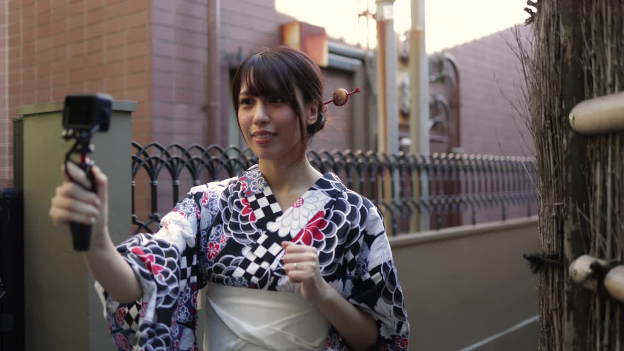 一名日本女子在一条狭窄的小路上发视频视频素材