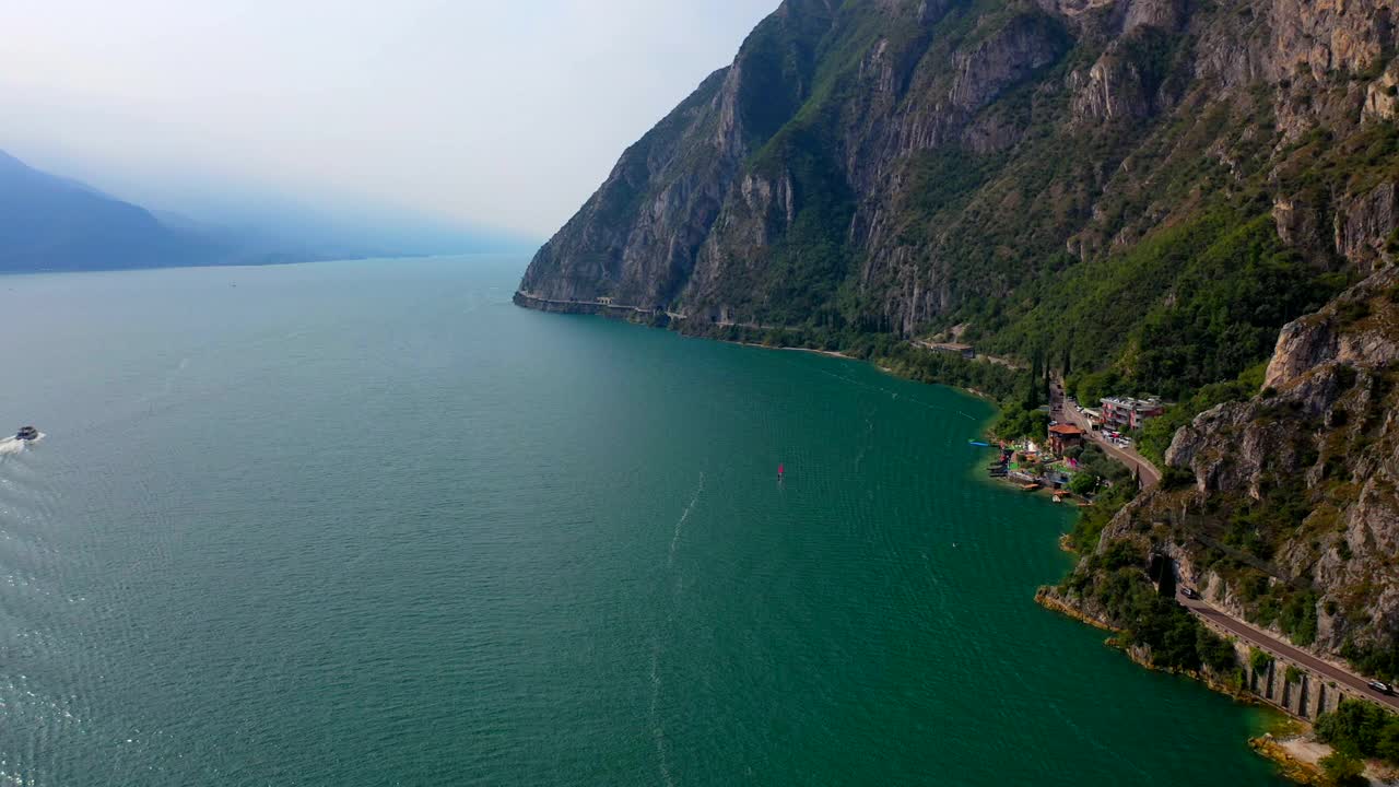 无人机拍摄到一艘船在山脉附近的湖泊上行驶视频下载