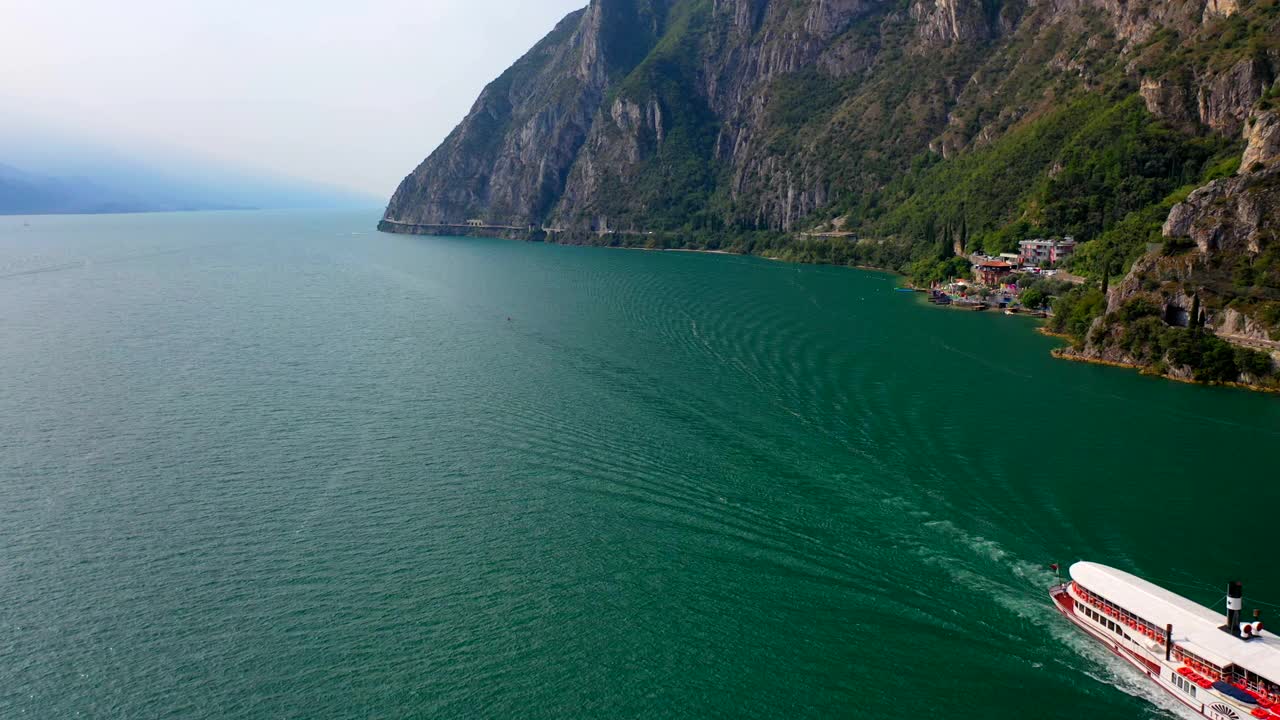 无人机拍摄到一艘船在山脉附近的湖泊上行驶视频下载