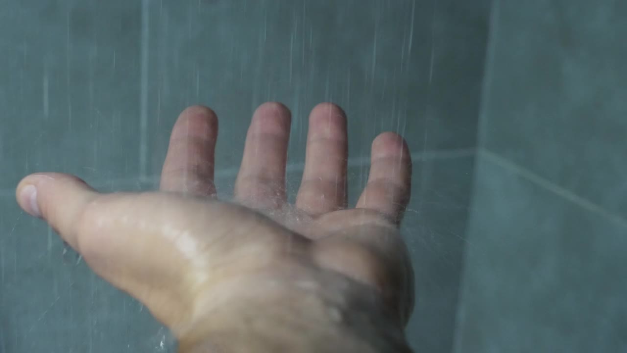 水溅在人的手掌上，水从淋浴喷头流出视频素材