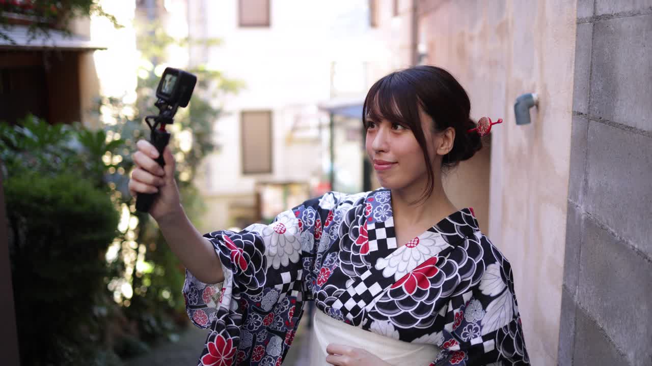 一名日本女子在一条狭窄的小路上发视频视频素材