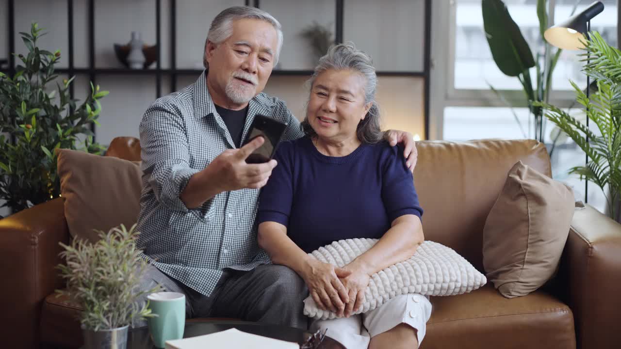 幸福的亚洲老年夫妇在手机摄像头前微笑自拍。视频素材