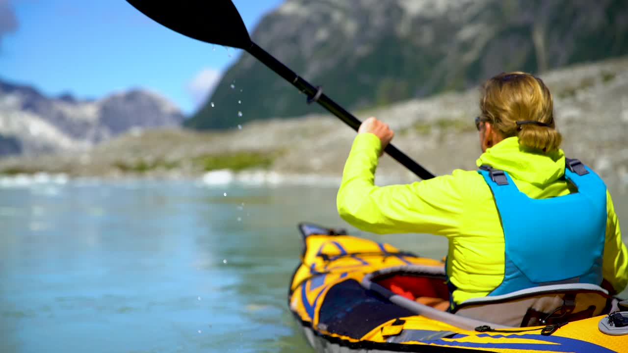 不列颠哥伦比亚省女冒险家在冰山湖上划独木舟视频素材