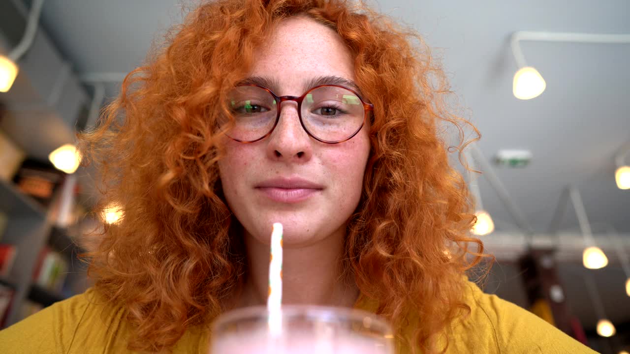 一个迷人的和美丽的红发年轻女子的肖像享受她的健康的思慕雪视频下载