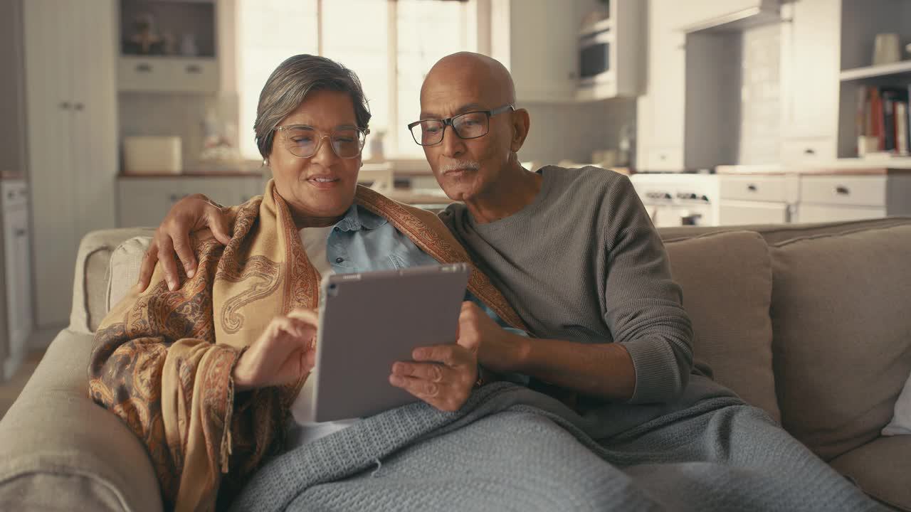 一对老夫妇在家里使用数字平板电脑的4k视频片段视频素材