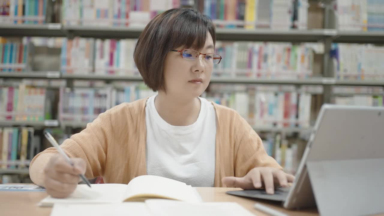 亚洲女人在图书馆用笔记本电脑视频下载