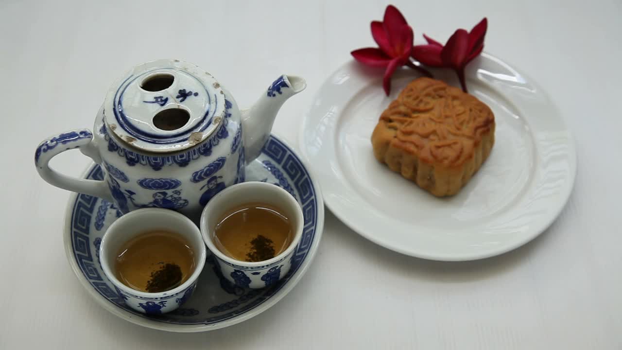 中国茶具，月饼和红色花朵，自然光线，背景视频素材