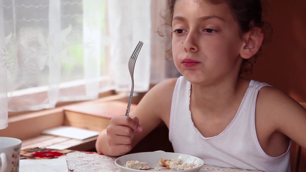 小女孩在吃饭的时候亲吻叉子视频素材