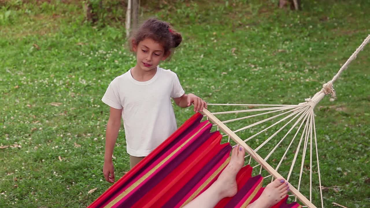 小女孩在后院里的吊床上摇着别人视频下载